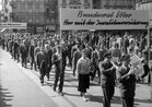 Corteo del 1° maggio: manifestazione con musicisti e uno striscione "Bundesrat Etter, her mit der Invalidenversicherung", 1957. Archivio sociale svizzero, Zurigo.