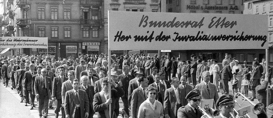 Corteo del 1° maggio: manifestazione con musicisti e uno striscione, 1957, Fonte: Schweizerisches Sozialarchiv, Zürich.