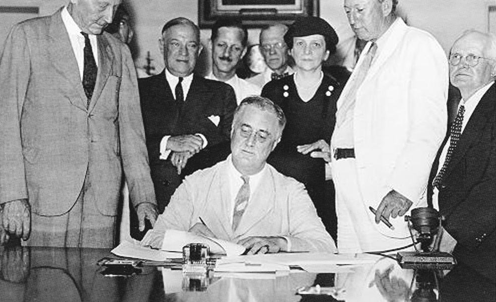 Il presidente americano Franklin D. Roosevelt firma il Social Security Act, 14 agosto 1935. Social Security Agency (Internet).